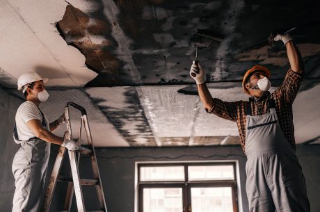 Professional technicians repairing ceiling water damage in an Alexandria home, removing damaged drywall and ensuring safe restoration after a leak.