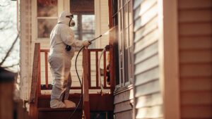 Technician in protective suit performing 24 hour biohazard cleanup at a residential property in Alexandria VA during an emergency response.