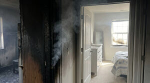 Smoke spreads from a fire-damaged room into an unaffected bedroom, showing hidden smoke damage beyond the fire area.