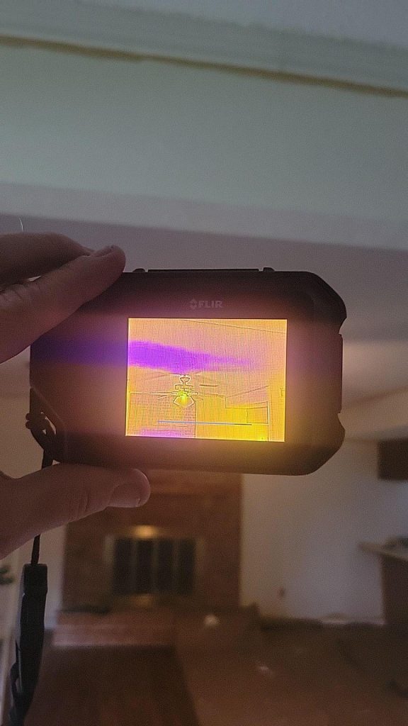 An infrared camera captures moisture levels in the ceiling.