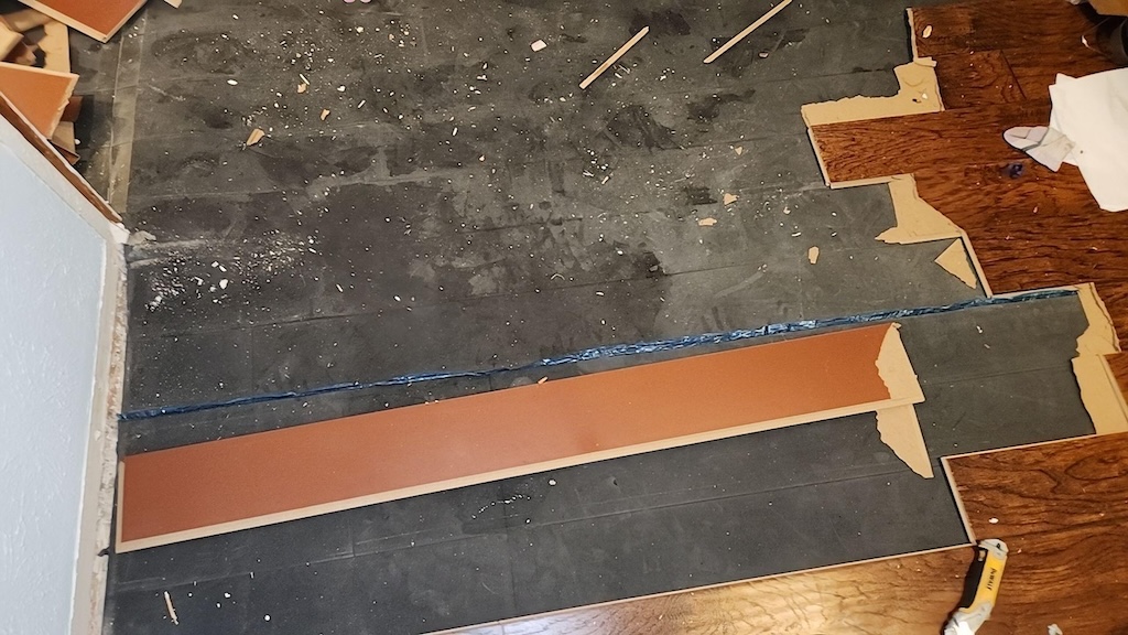 Wet damaged vinyl flooring from water heater leak.