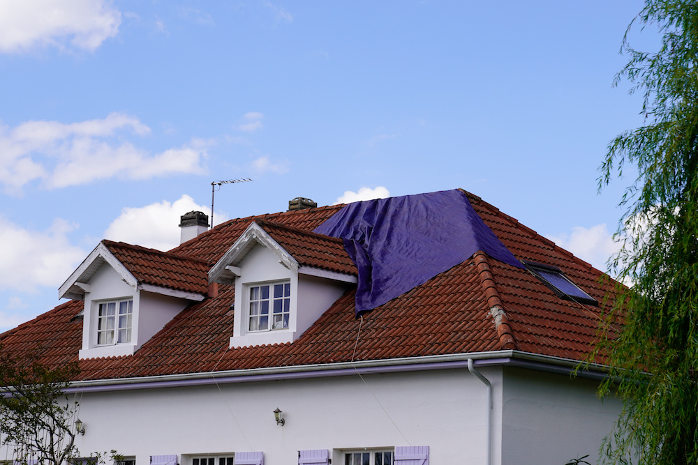 A leaky roof with a tarp over it
