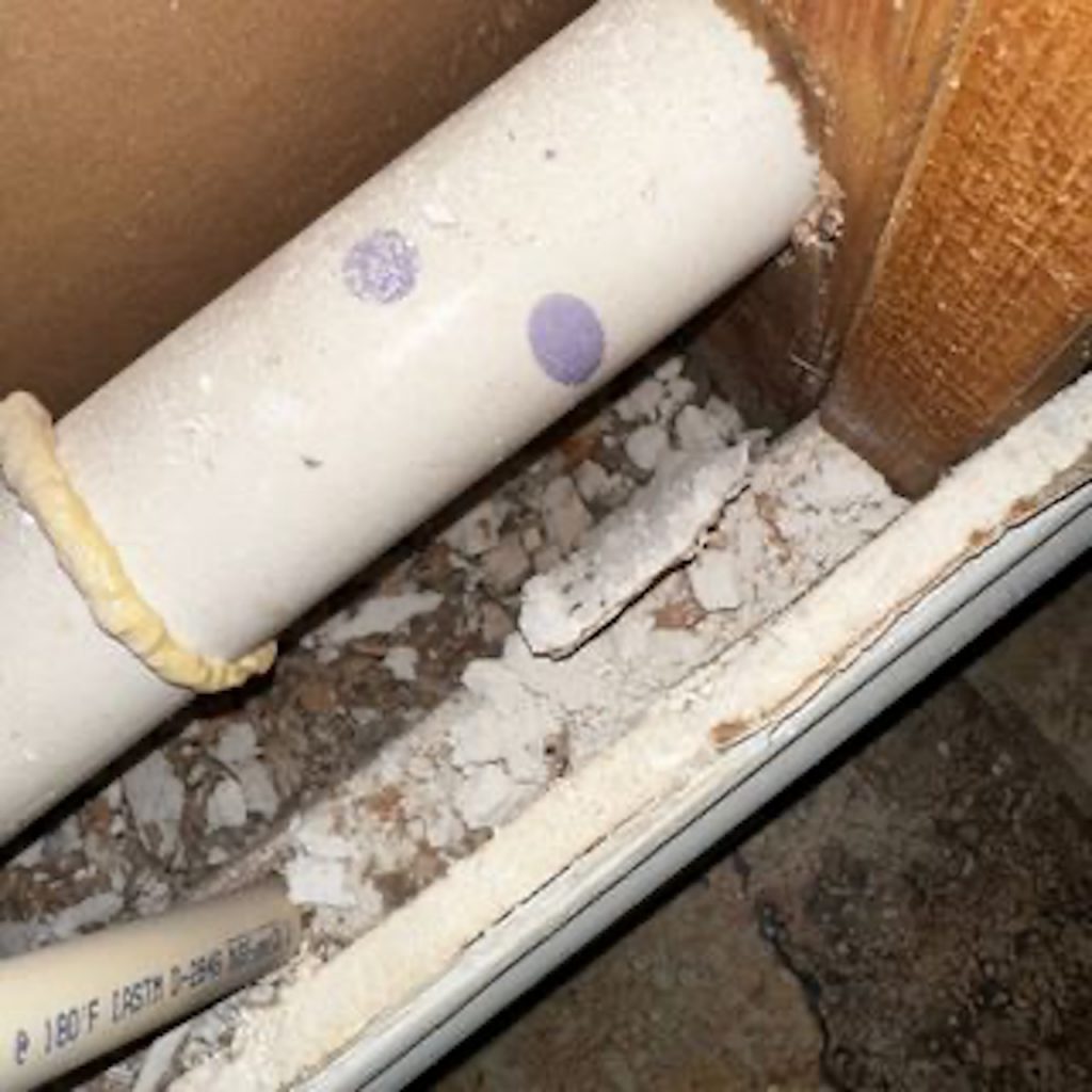 Mold growth under a pipe.