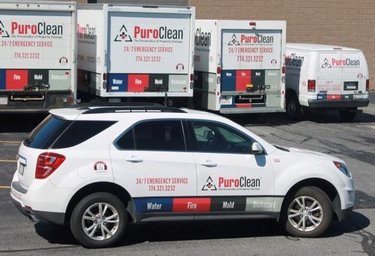 Puroclean vehicles parked in front of a job site