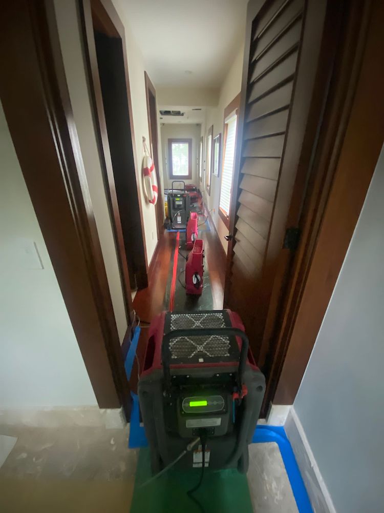 Our HEPA-certified dehumidifiers and air movers set up in the hallway of a home that experienced flooding
