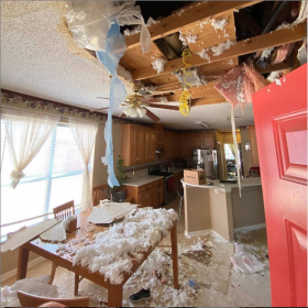 Extensive ceiling damage with insulation and debris covers a dining room and kitchen area.