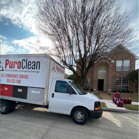 A PuroClean emergency service truck is parked outside a brick house for property damage restoration.
