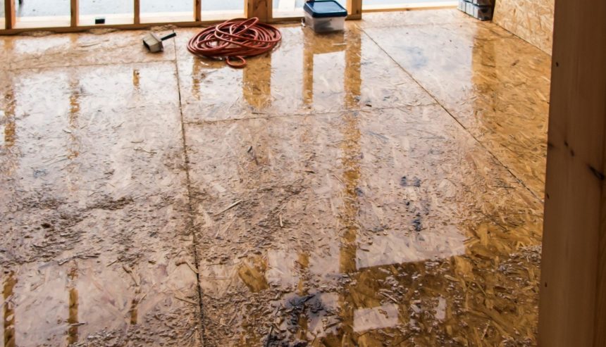 Water-damaged OSB subfloor covered in standing water and