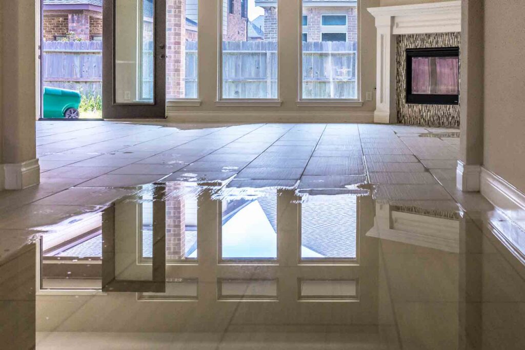 Flooded tile floor in a residential living room caused by one of the common causes of water damage in Bloomington homes.