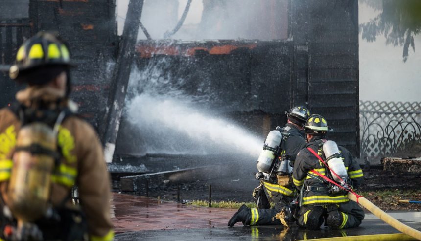 firefighters spraying water to put out a house fire