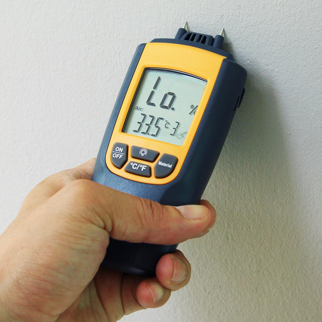 man using a moisture meter in a home