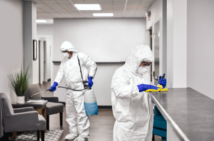 Biohazard cleanup in Bradenton FL professional applying EPA-registered disinfectant to contaminated surface