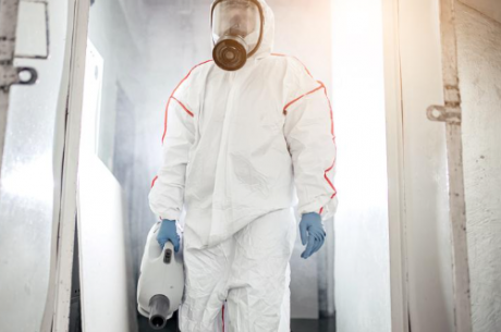 Certified biohazard cleanup Bradenton FL technician in full PPE removing hazardous waste