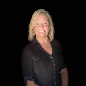 Smiling blonde woman in a black shirt and necklace against