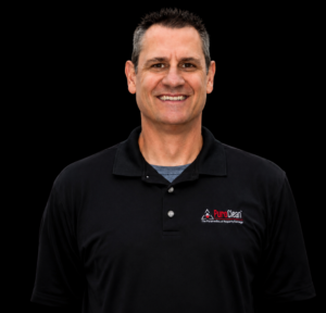 A smiling man in a black PuroClean polo shirt against a black background. TITLE