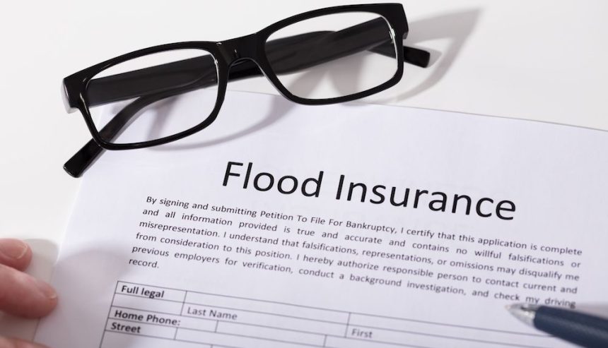 A flood insurance policy with a pair of glasses placed on it