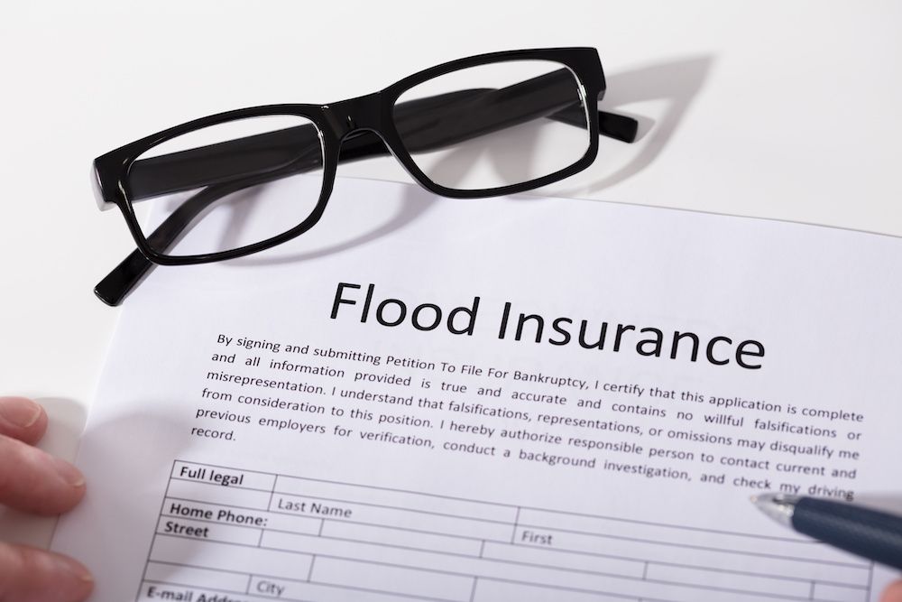 A flood insurance policy with a pair of glasses placed on it