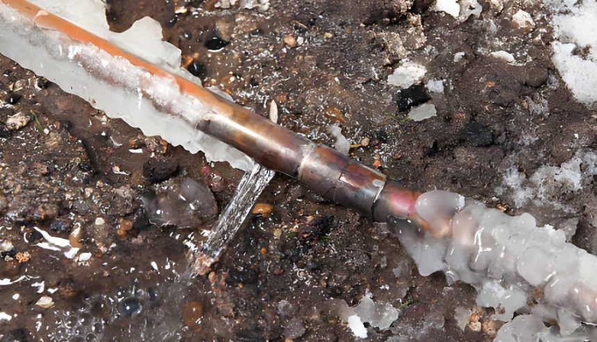 Burst copper pipe with ice and water damage on the ground, illustrating emergency water damage repair.