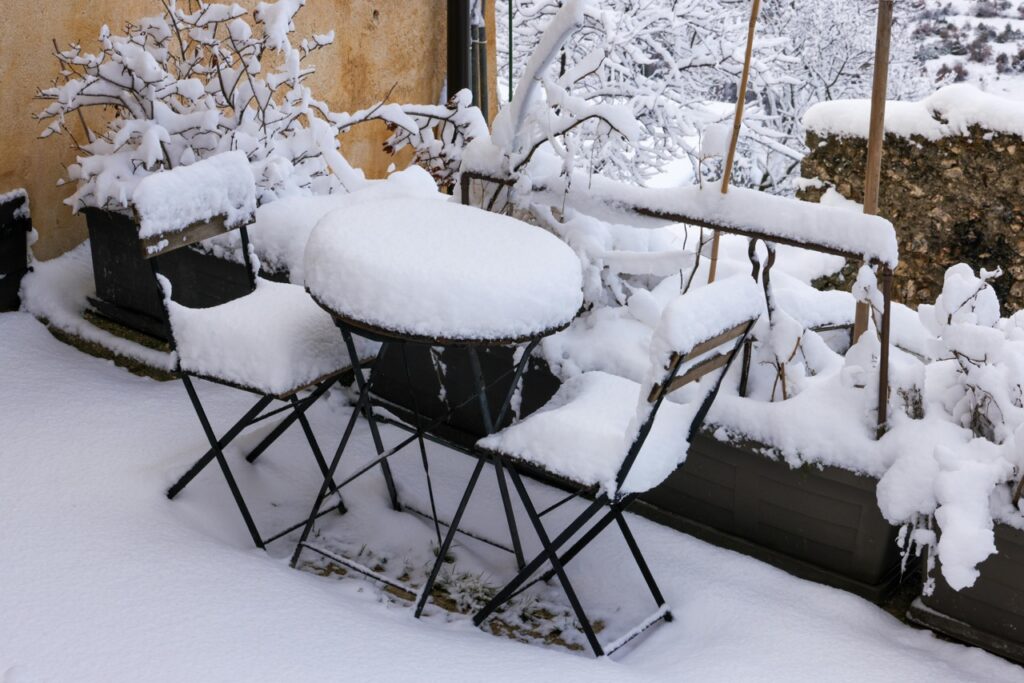 Snow-covered patio in Alpharetta showing cold weather conditions that can lead to frozen plumbing — take steps to prevent burst pipes in Metro Atlanta.