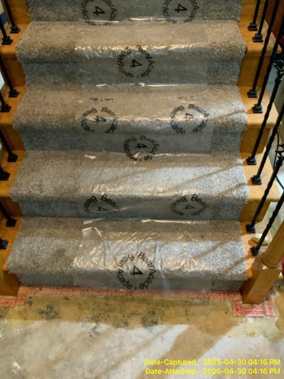 Carpeted stairs covered with protective film to prevent contamination during sump pump failure cleanup in Edwardsville, IL basement.
