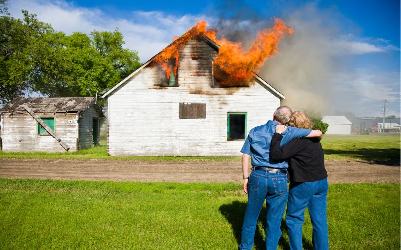 couple watching their house catch on fire