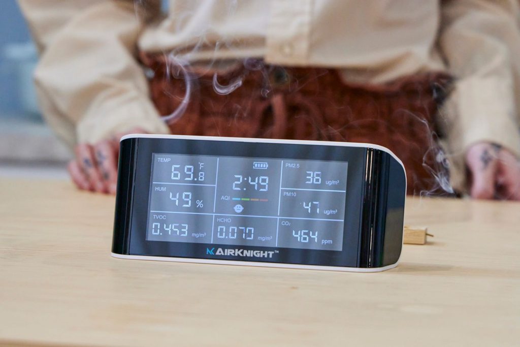 Indoor air quality specialist using air monitoring equipment in a restored home