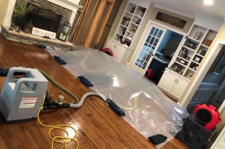 water damage restoration professionals drying flooded residential home interior