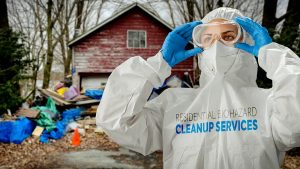 Certified biohazard cleanup technician in full protective equipment preparing to remediate a contaminated property in Centennial CO