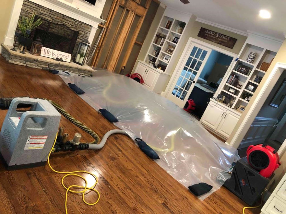 water damage restoration professionals drying flooded residential home interior
