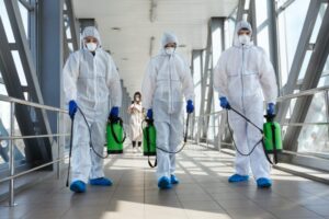 professional biohazard cleanup technician in full PPE performing sanitization