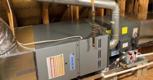 A grey Daikin HVAC air handler unit with metal ductwork and pipes is installed in