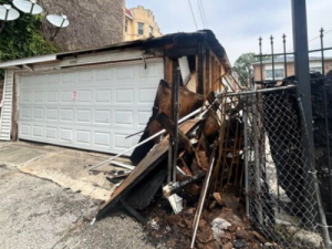 Garage exterior with heavy fire and smoke damage to siding and structure, highlighting the importance of professional smoke damage restoration services.