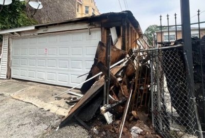 Garage exterior with heavy fire and smoke damage to siding and structure, highlighting the importance of professional smoke damage restoration services.