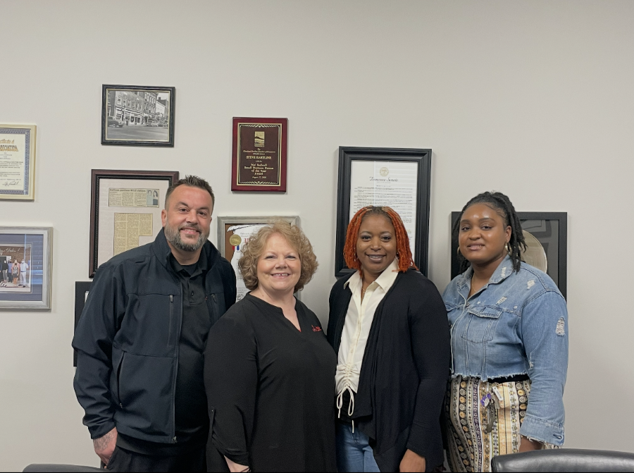 Four smiling people, two men and two women,