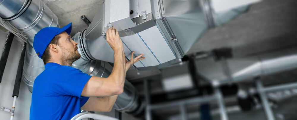 Technician inspecting duct system