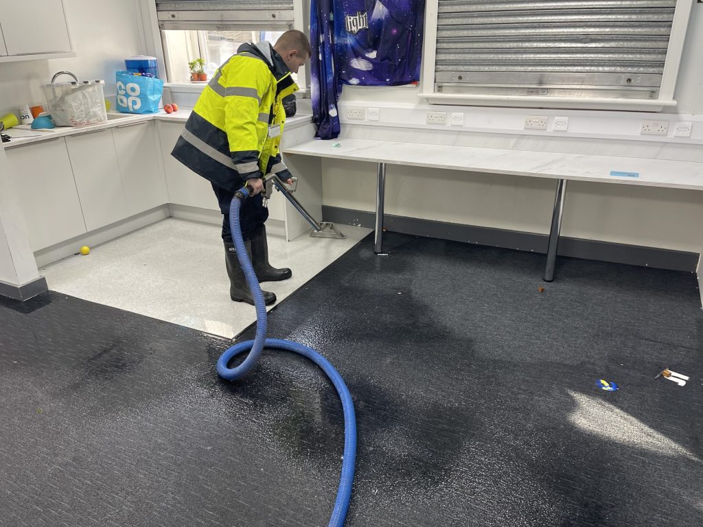 Restoration technician arriving at a flooded home with drying equipment