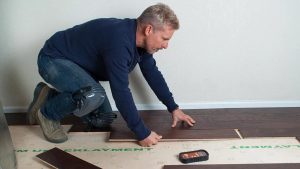 Technician using moisture meters on flooring wet from firefighting water