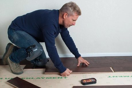 Technician using moisture meters on flooring wet from firefighting water