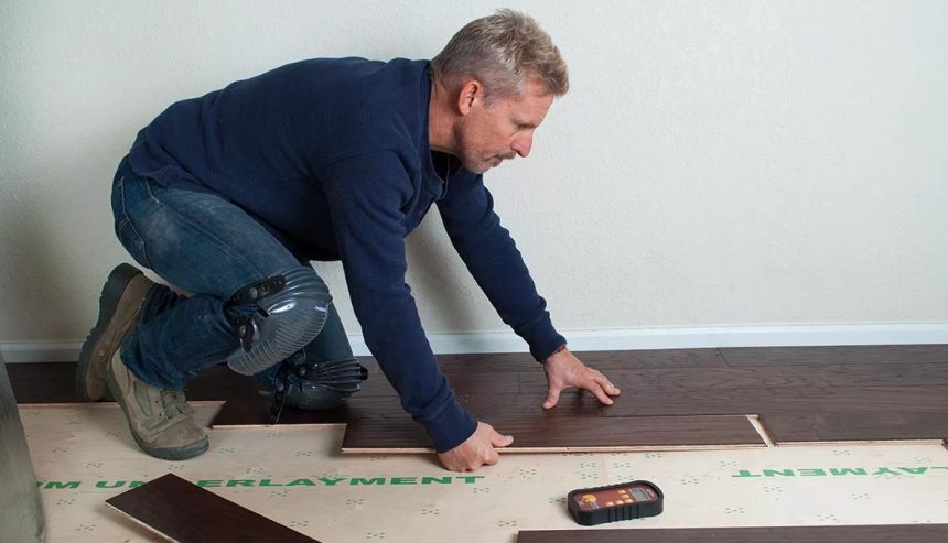 Technician using moisture meters on flooring wet from firefighting water