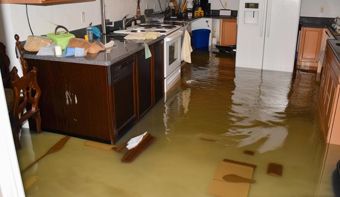 flood damage restoration team using industrial equipment to dry a flooded Covington LA home
