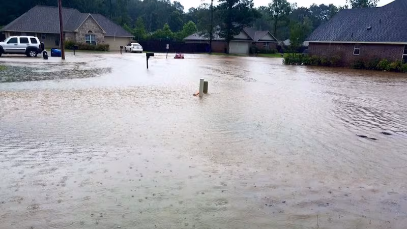 Flooded residential subdivision street in Mandeville LA during a heavy rainfall event requiring professional flood clean up response