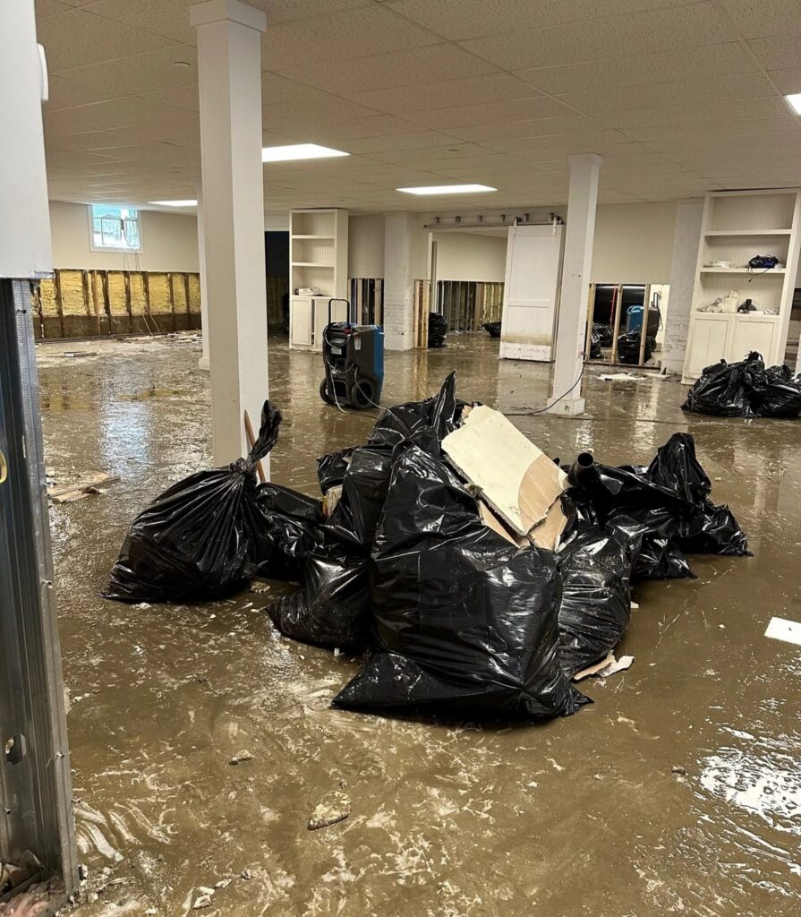 Professional flood clean up crew working alongside faith community members to restore a flooded church interior in Covington LA with proper contamination protocols and equipment