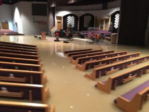 Flood clean up assessment inside a flooded church or house of worship in Covington LA showing water damaged pews and interior requiring professional restoration response