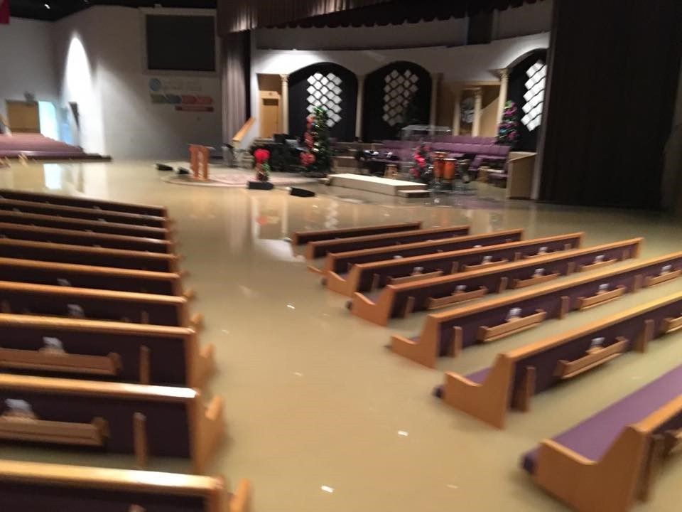 Flood clean up assessment inside a flooded church or house of worship in Covington LA showing water damaged pews and interior requiring professional restoration response