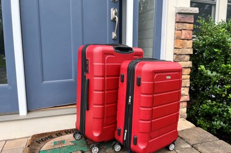 Two suitcases packed for vacation and outside the front door