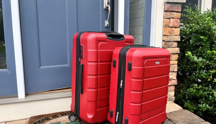 Two suitcases packed for vacation and outside the front door