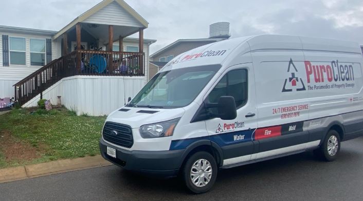 White PuroClean van offering property damage restoration services parked outside a residential home. TITLE: