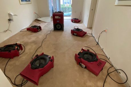 Air movers set up to dry areas affected by broken toilet supply line