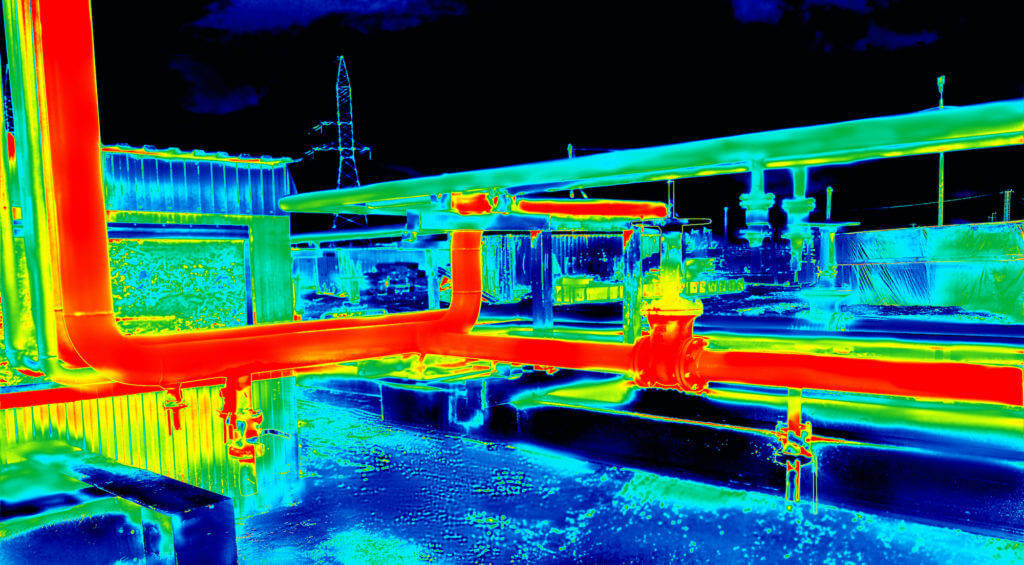 Thermal infrared image showing hot red industrial pipes and cooler blue structures at a facility.