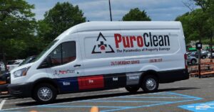 A white PuroClean van, advertising 24/7 emergency property damage restoration services, is parked in a lot.